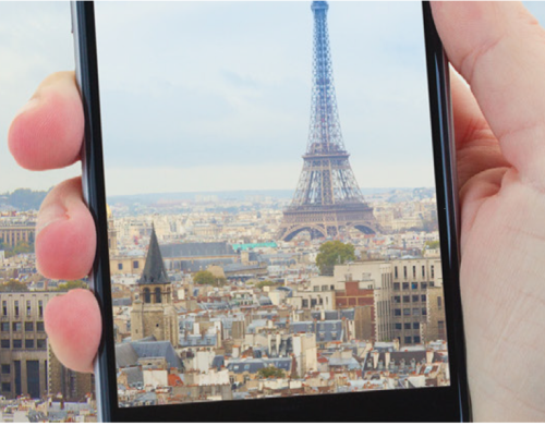cybersecurity while traveling thumbnail Cybersecurity while traveling image - person holding phone taking picture of eiffel tower