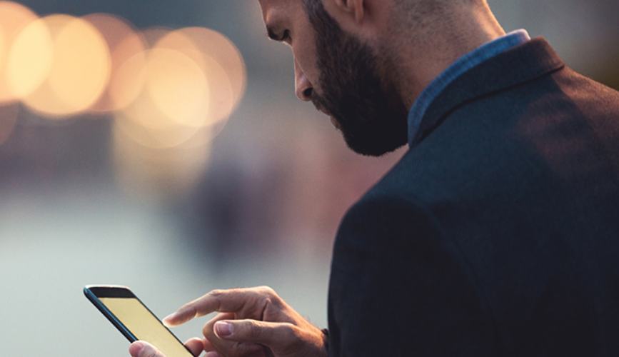 Man looking at phone in hands blurred background