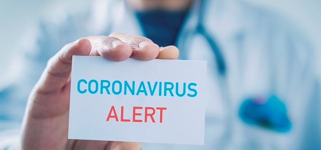 Physician holding card saying Coronavirus Alert
